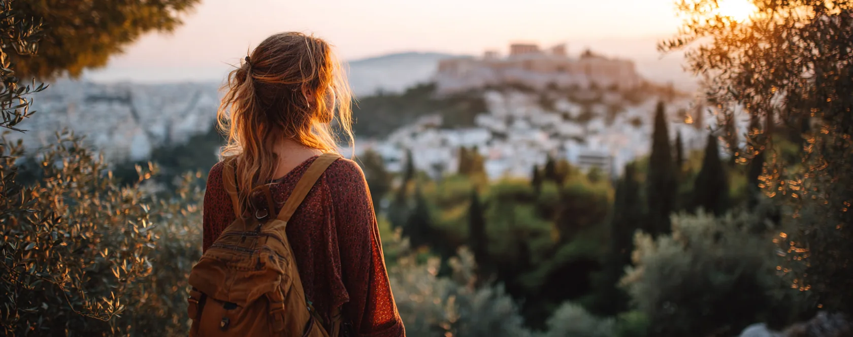 Μαθητής με σακίδιο κοιτάζει την Ακρόπολη στο ηλιοβασίλεμα